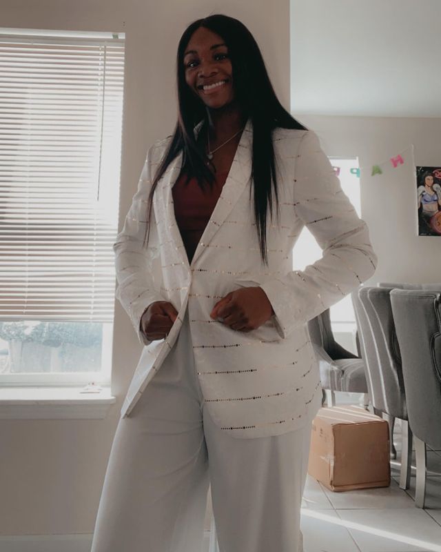 Claressa Shields smiling in white suit