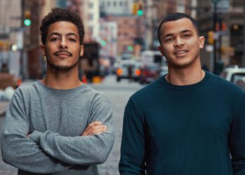 two black college students looking confident city street background