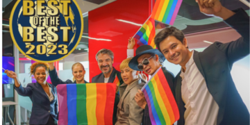 diverse group of business people (man, woman, gay, transgender, lesbian, asian, caucasian, african american, lgbtq) with rainbow flag on hand combine together as teamwork in office, selective focused