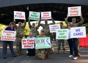 veteran advocates lined up holding signs in support of suicide prevention