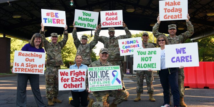 veteran advocates lined up holding signs in support of suicide prevention