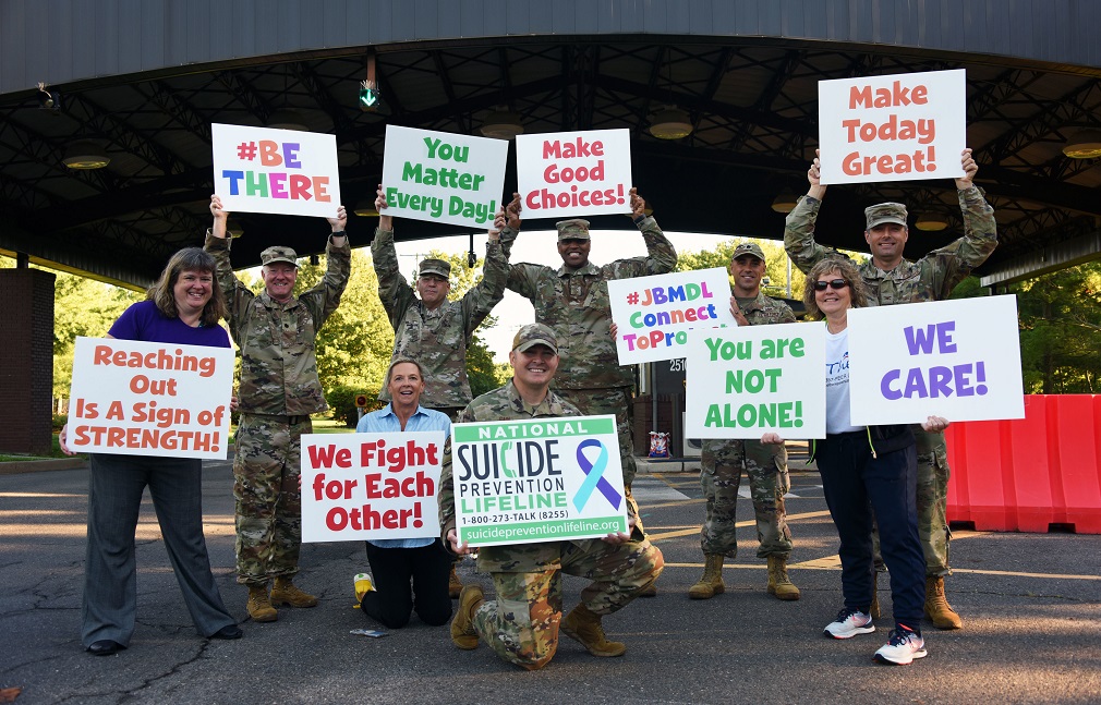 veteran advocates lined up holding signs in support of suicide prevention