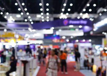 Abstract blur people in exhibition hall event trade show expo background. Business convention show, job fair, or stock market. Organization or company event, commercial trading, or shopping mall marketing advertisement concept.