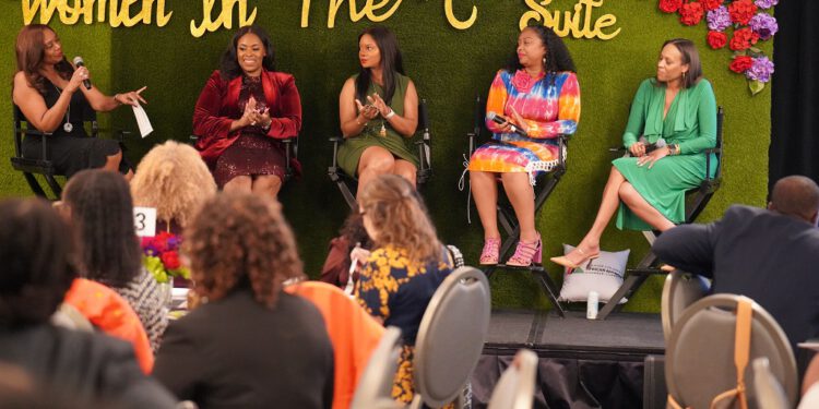 GLAAACC’s 2023 Women in the C-Suite sit onstage together with a colorful bouquet of flowers