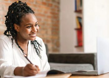 black woman studying at desk smiling