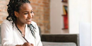 black woman studying at desk smiling