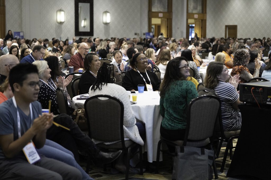 Attendees clapping and smiling during a presentation at The Arc Conference