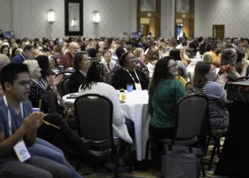 Attendees clapping and smiling during a presentation at The Arc Conference