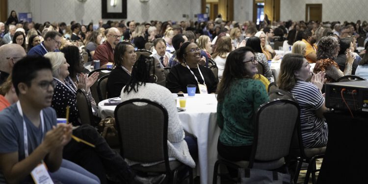 Attendees clapping and smiling during a presentation at The Arc Conference