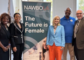 NAWBO participants stand in front of large promotional sign for the event