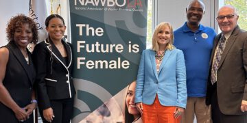 NAWBO participants stand in front of large promotional sign for the event