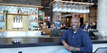 Rustik Taverns Owner Frantz Metellus Poses In Front Of The Restaurants Bar. Photo Credit_ Karen Juan.jpeg